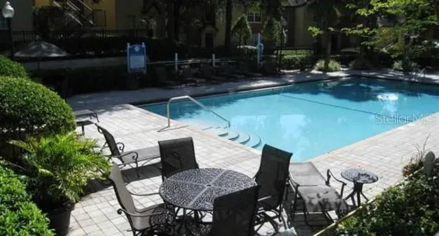 a view of backyard with swimming pool and outdoor seating