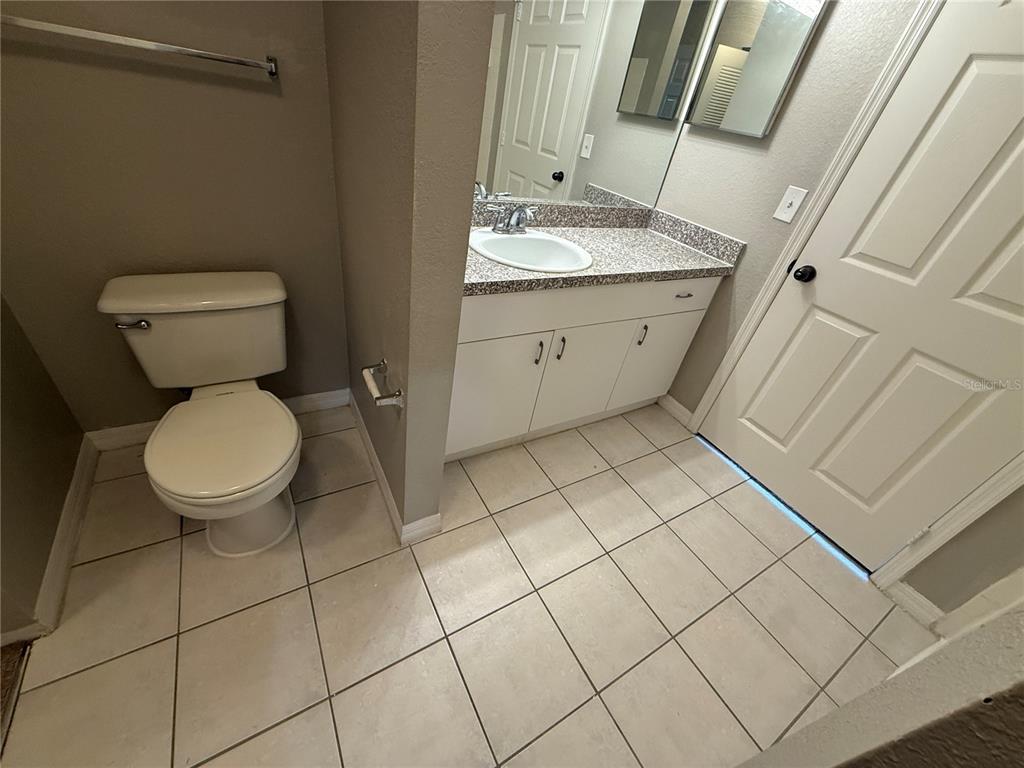 6312 Raleigh Street, Unit 512 Orlando, FL 32835 - Photo 7 of 17 a bathroom with a toilet sink and mirror