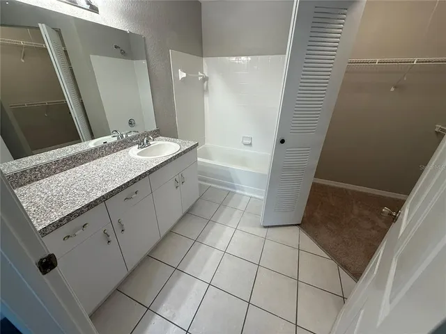 a bathroom with a granite countertop sink a toilet and a mirror