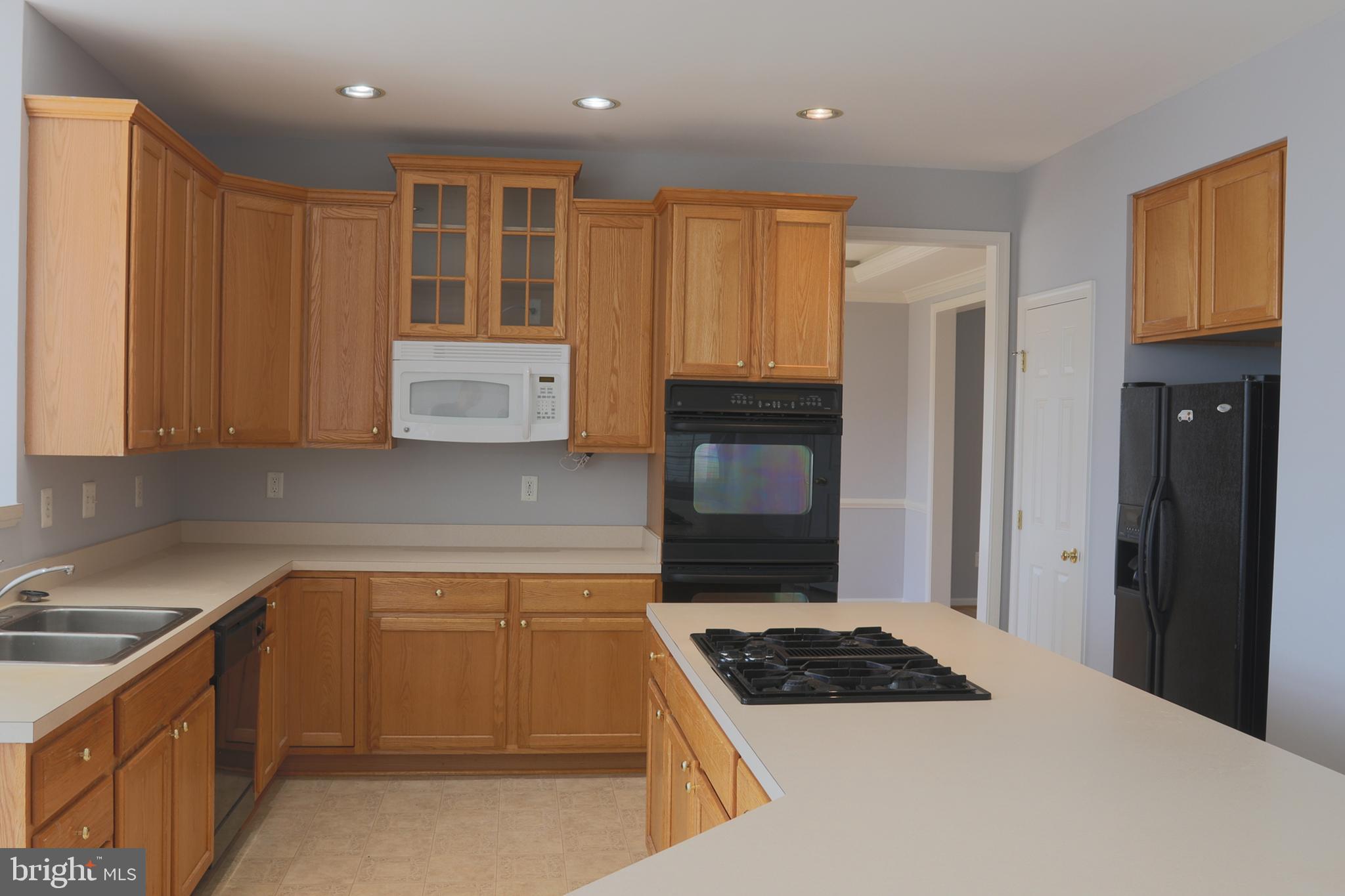 14404 Autumn Crest Road Boyds, MD 20841 - Photo 91 of 103 a kitchen with stainless steel appliances granite countertop a stove a sink and a refrigerator with wooden cabinets
