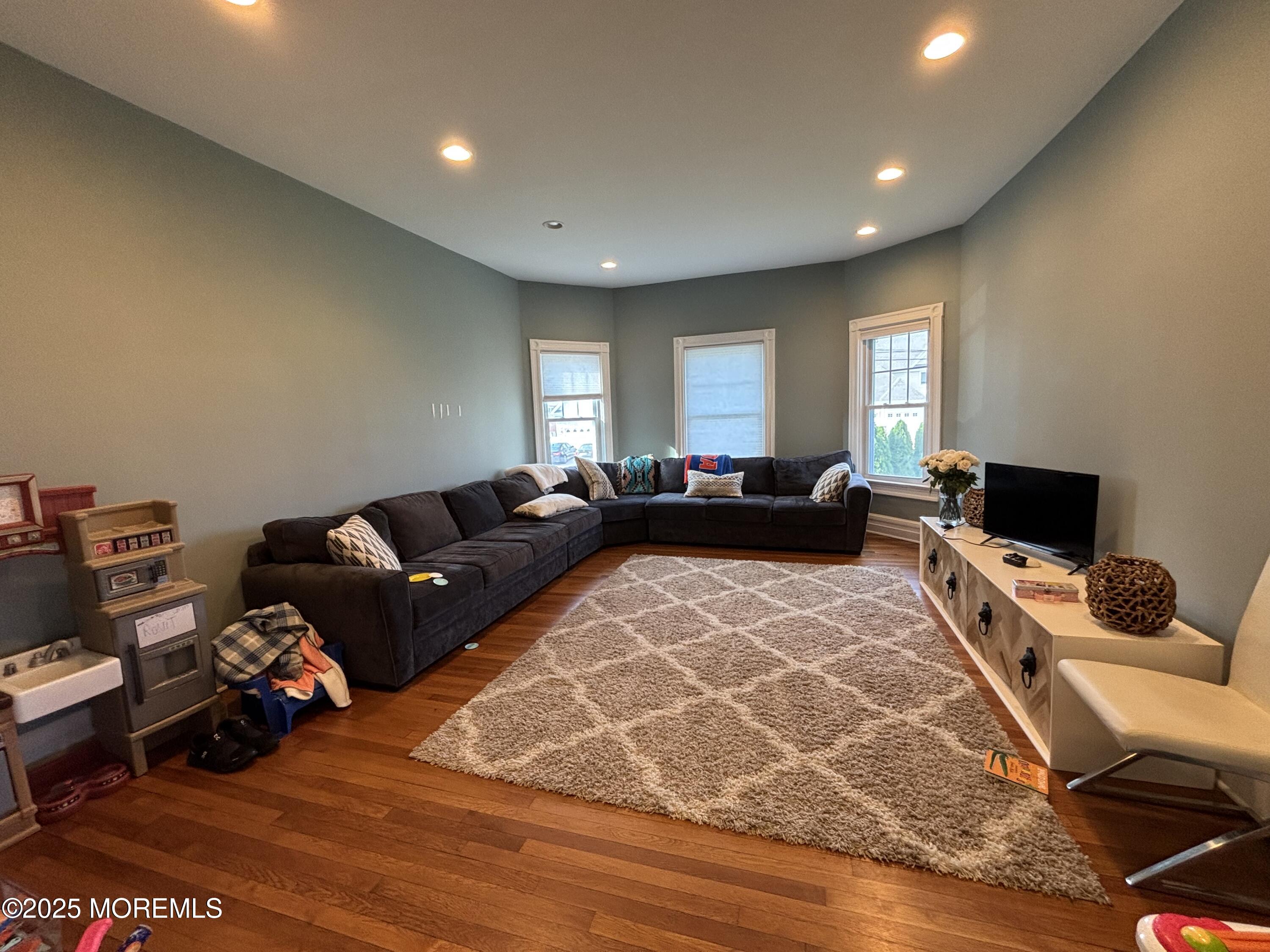 516 2nd Avenue Long Branch, NJ 07740 - Photo 12 of 52 a living room with furniture a bed and a flat screen tv
