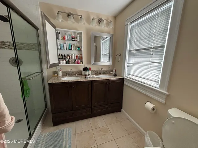a bathroom with a granite countertop sink mirror and toilet