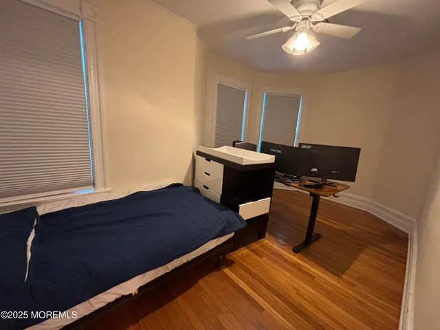 a bedroom with a bed and wooden floor