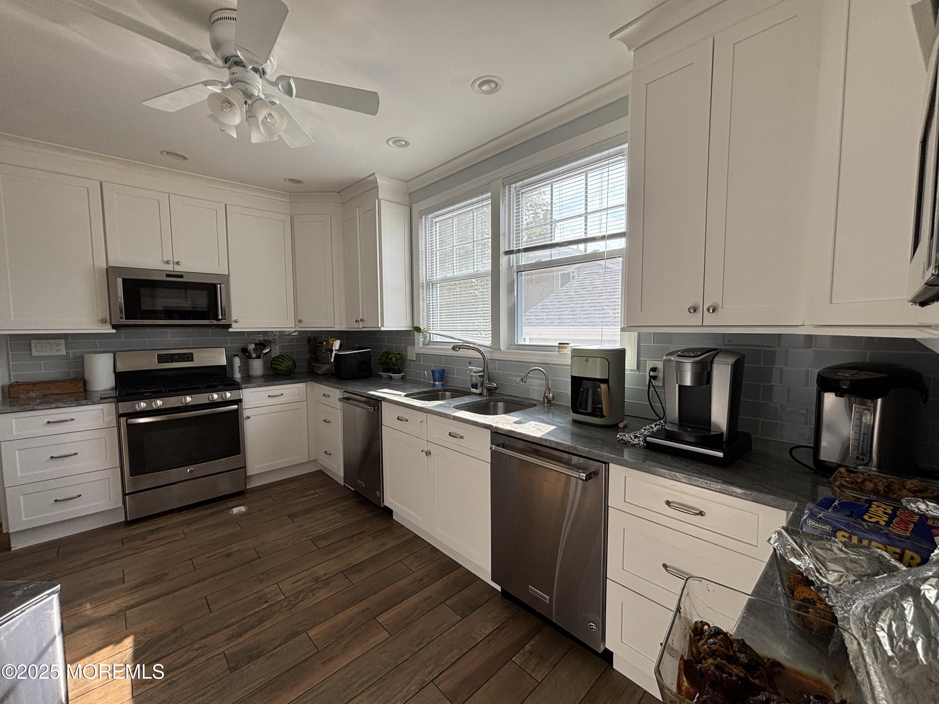 516 2nd Avenue Long Branch, NJ 07740 - Photo 8 of 52 a kitchen with granite countertop a stove a sink dishwasher and a microwave oven on the wooden floor