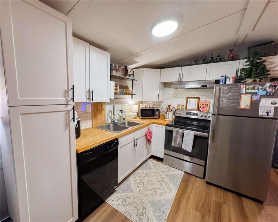 10 Lindsey Lane Northwest Rome, GA 30165 - Photo 8 of 16 a kitchen with kitchen island a sink wooden floor and stainless steel appliances