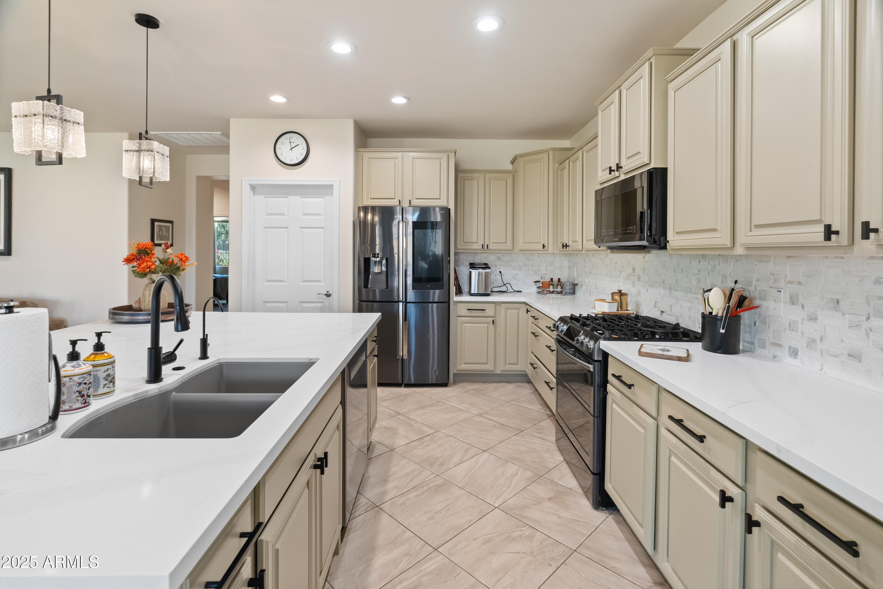 26990 West Utopia Road Buckeye, AZ 85396 - Photo 9 of 41 a kitchen with stainless steel appliances granite countertop a sink a stove and a refrigerator
