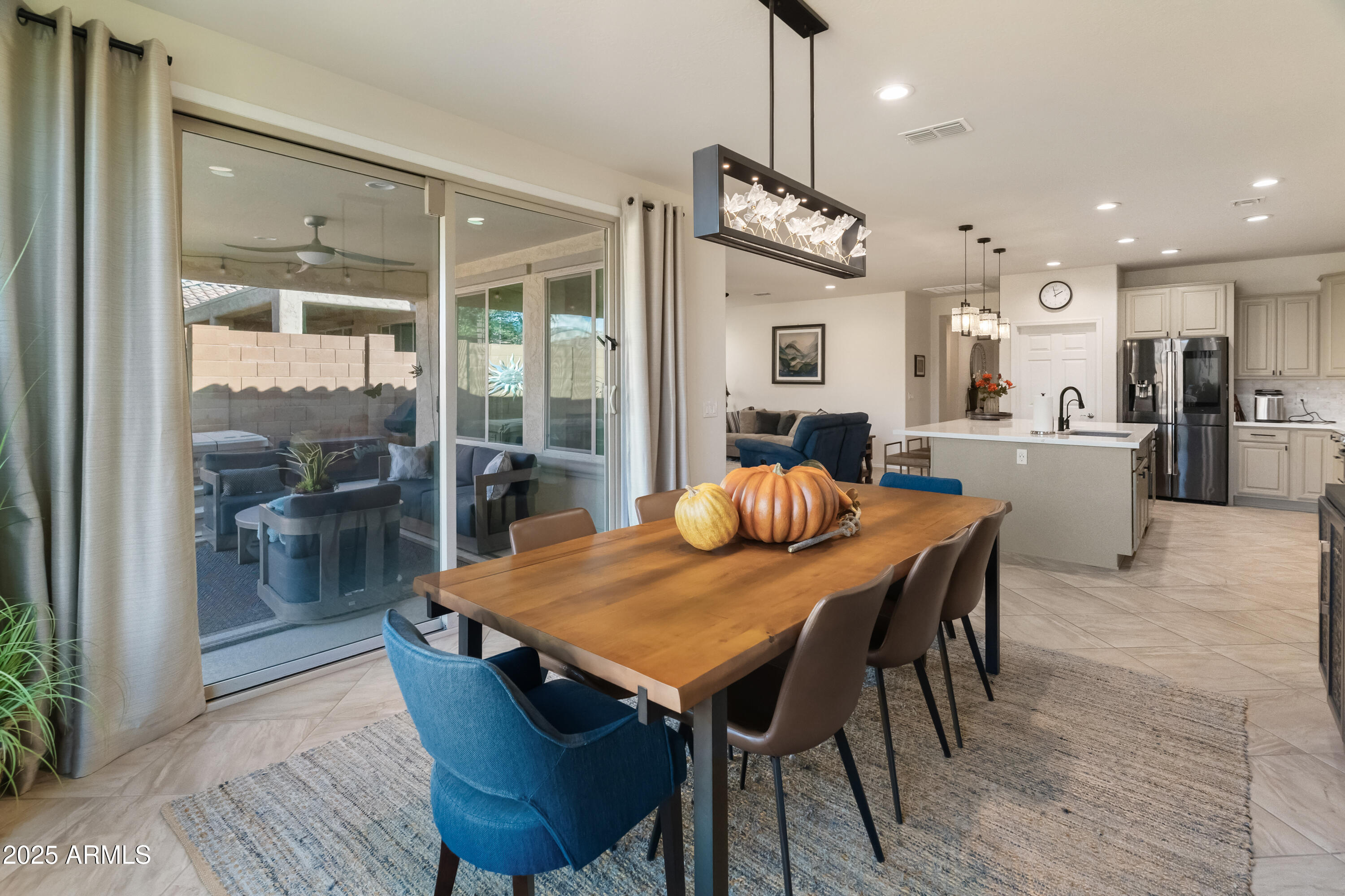 26990 West Utopia Road Buckeye, AZ 85396 - Photo 13 of 41 a view of a dining room and livingroom with furniture wooden floor a chandelier