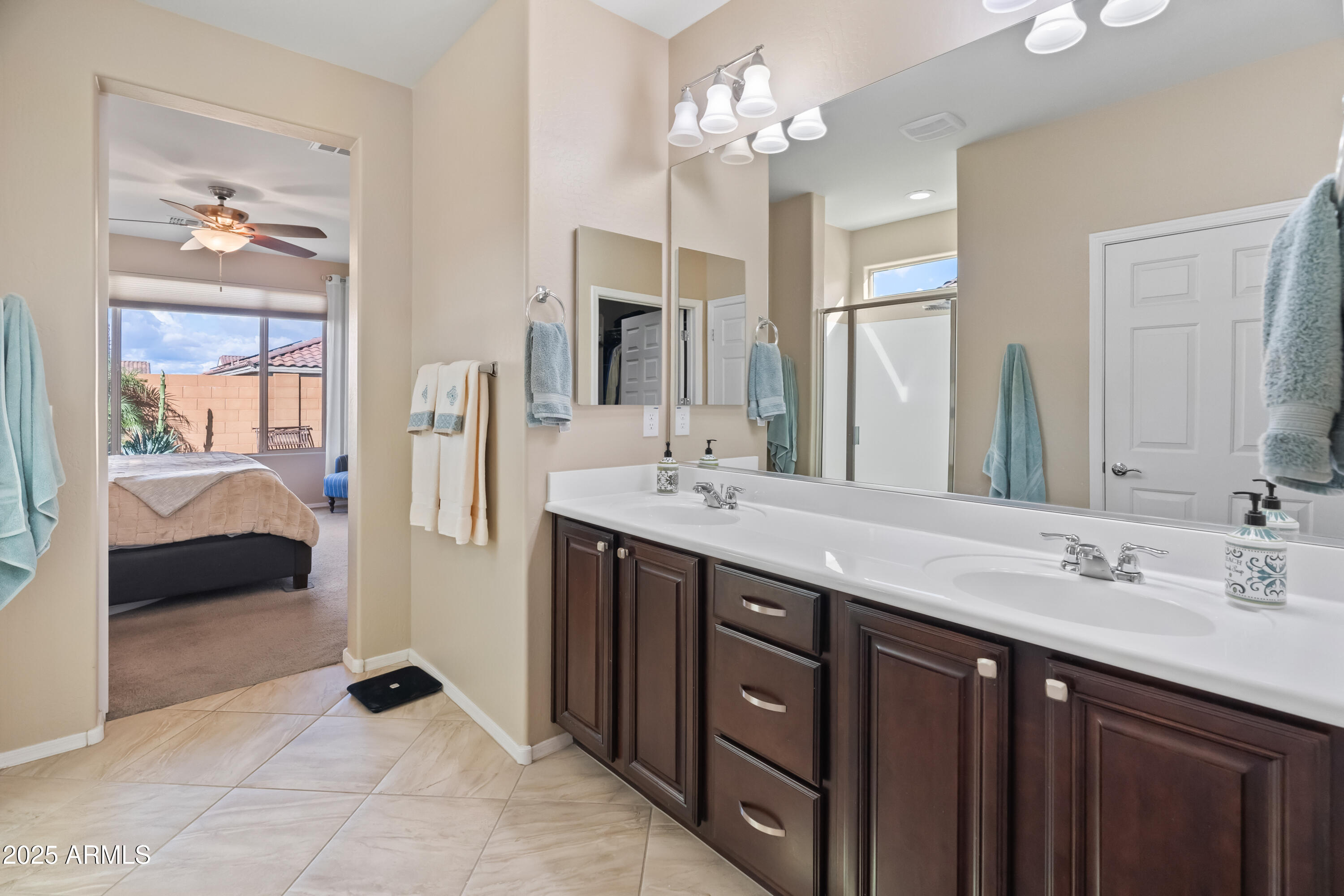 26990 West Utopia Road Buckeye, AZ 85396 - Photo 22 of 41 a spacious bathroom with a double vanity sink a mirror and a shower