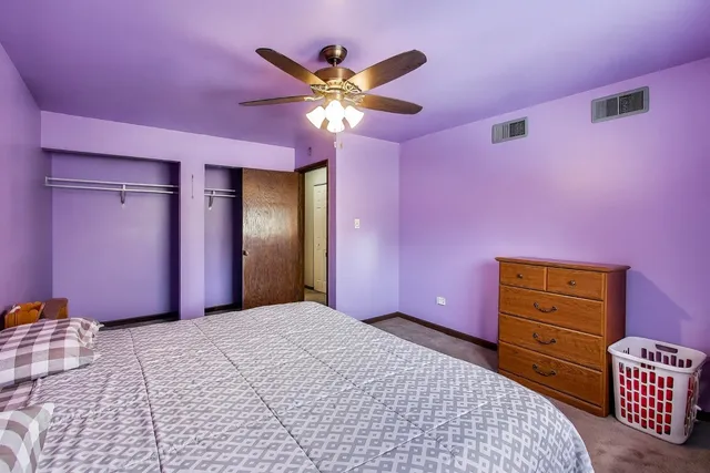 a bedroom with a bed chandelier and a dresser