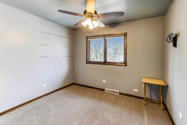 an empty room with a ceiling fan and a window