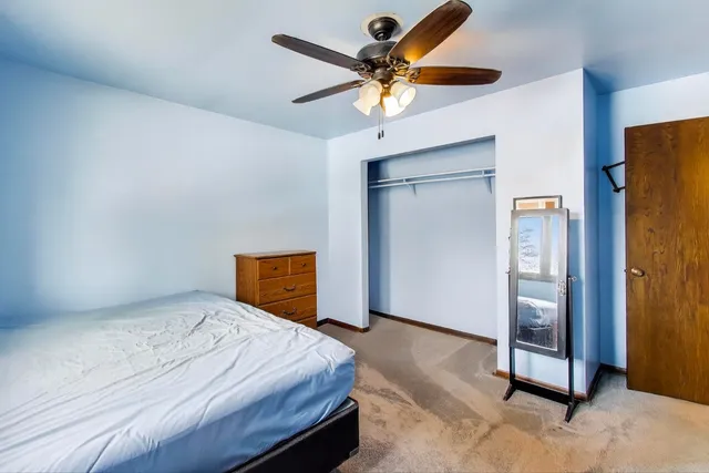 a bedroom with a bed and a ceiling fan