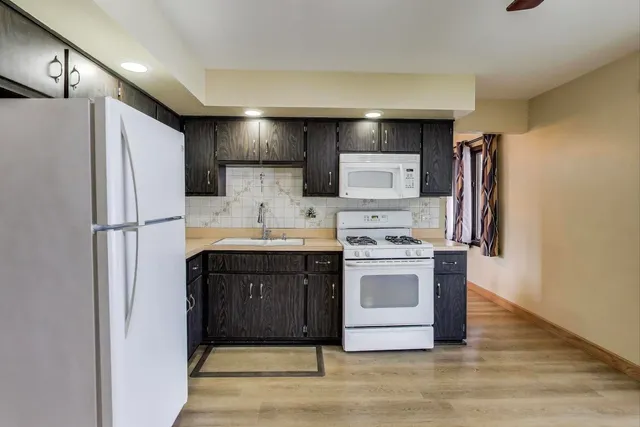 a kitchen with stainless steel appliances granite countertop a refrigerator and a stove
