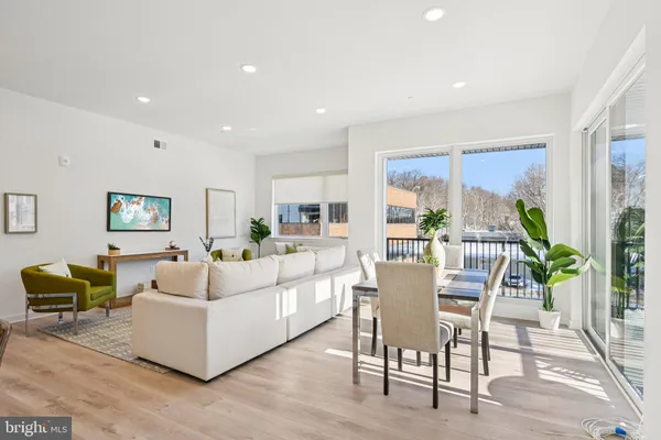 a living room with furniture wooden floor and a large window