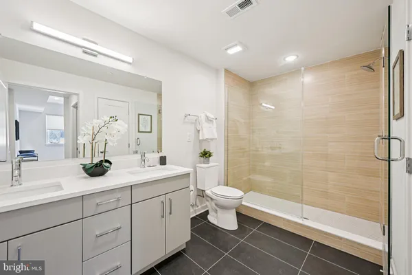 a bathroom with a double vanity sink toilet and shower