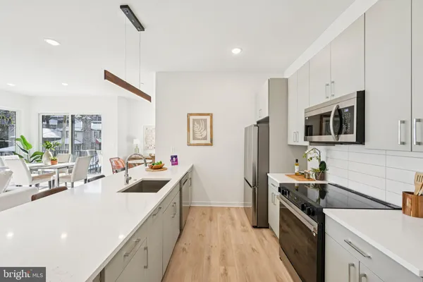 a kitchen with stainless steel appliances a sink dishwasher stove refrigerator and microwave