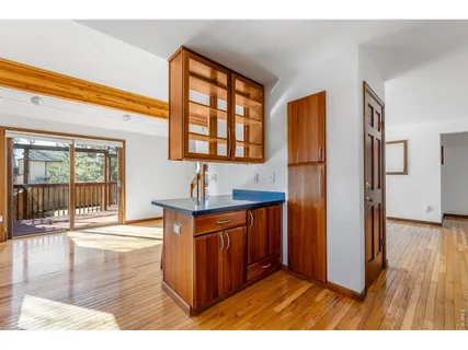 a open kitchen with stainless steel appliances granite countertop a refrigerator a sink dishwasher and a fireplace with wooden floor