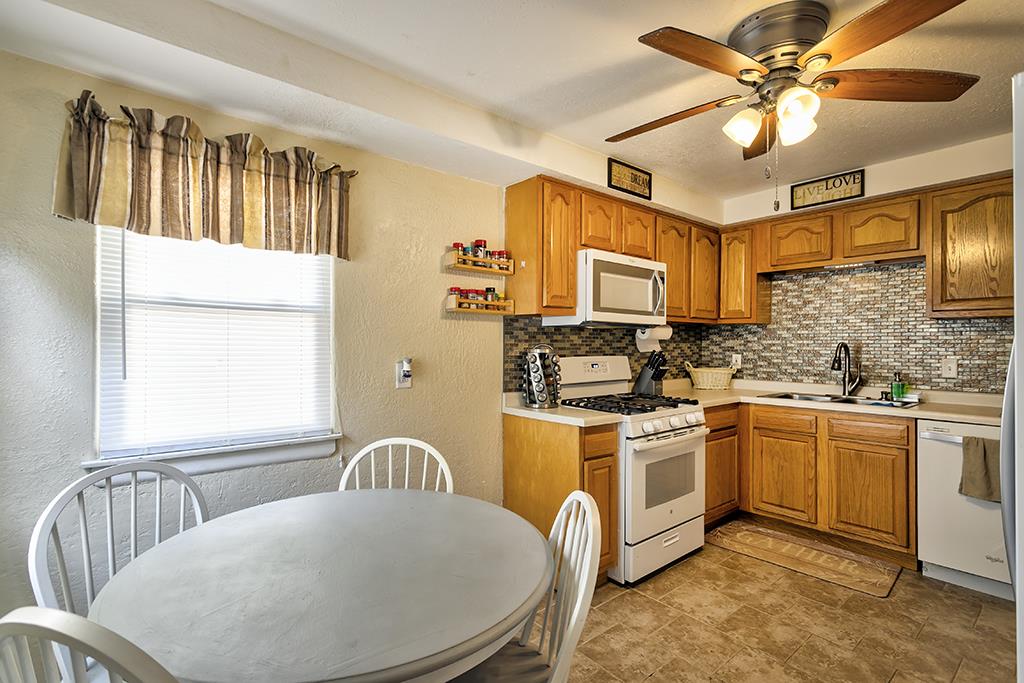 1923 Ridgeland Road Rockford, IL 61108 - Photo 8 of 21 a kitchen with stainless steel appliances granite countertop a stove a sink dishwasher a dining table and chairs with wooden floor