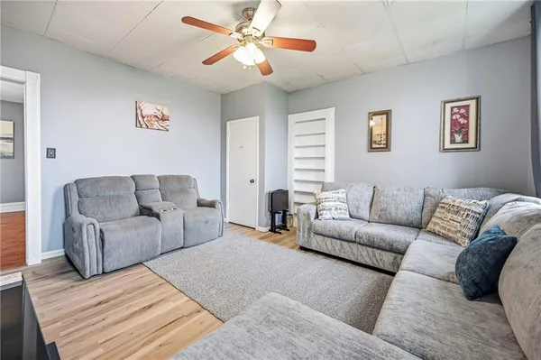 a living room with furniture and a ceiling fan