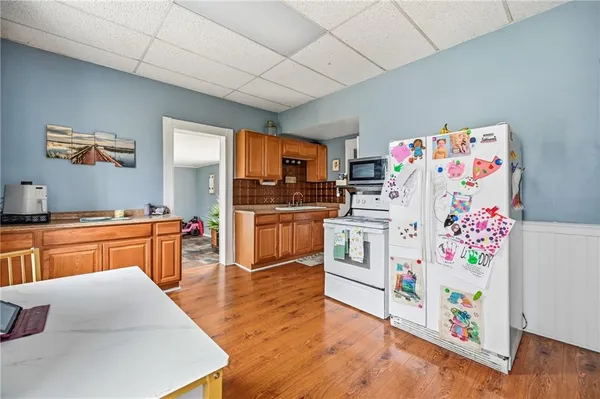 a kitchen with stainless steel appliances a stove a sink dishwasher and cabinets with wooden floor