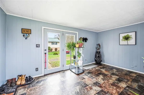 a view of an empty room with window and hardwood floor