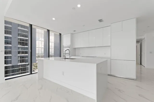 a view of kitchen with stainless steel appliances a refrigerator and cabinets
