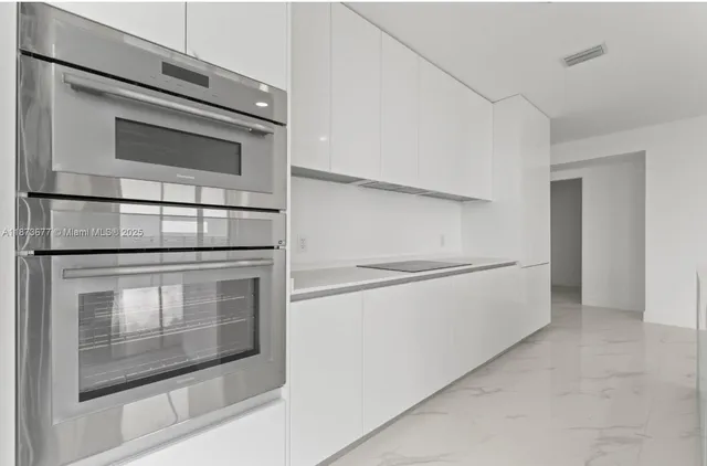 a kitchen with white cabinets and stainless steel appliances