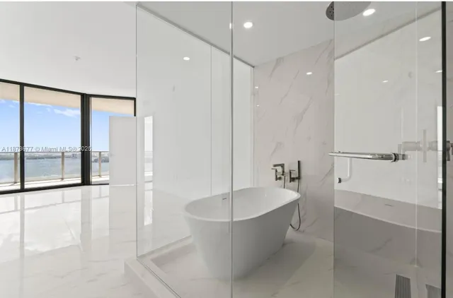 a bathroom with a tub a shower and view