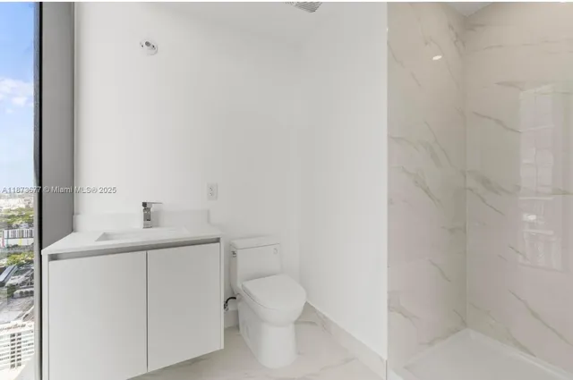 a bathroom with a toilet a sink and a window