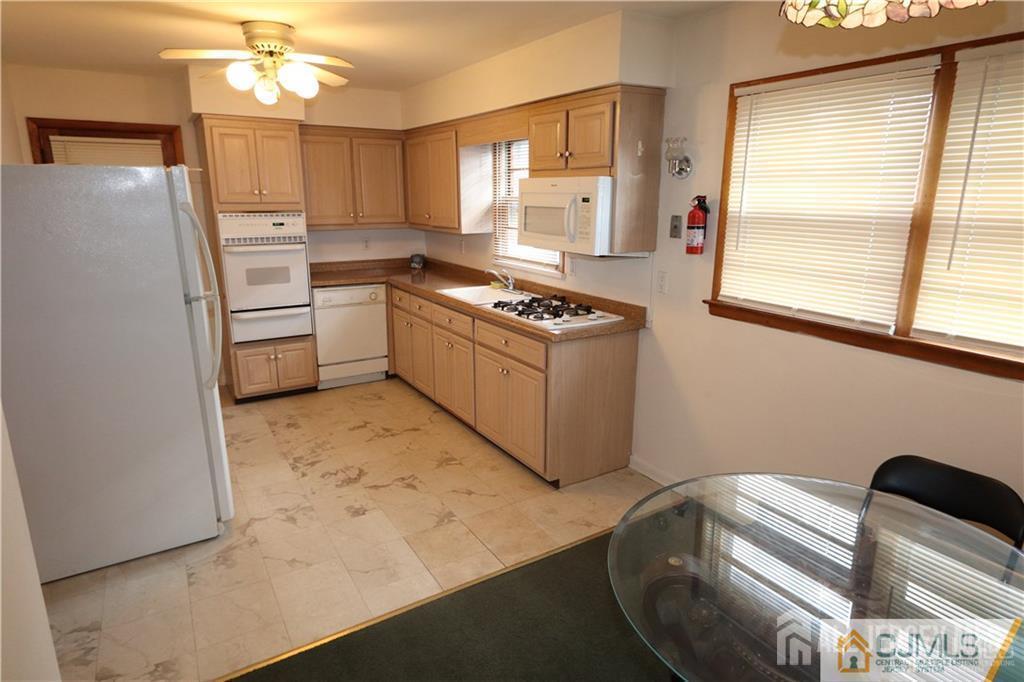 101 Stelton Road Piscataway, NJ 08854 - Photo 3 of 16 a kitchen with stainless steel appliances granite countertop a sink a stove a refrigerator a washer dryer and white cabinets