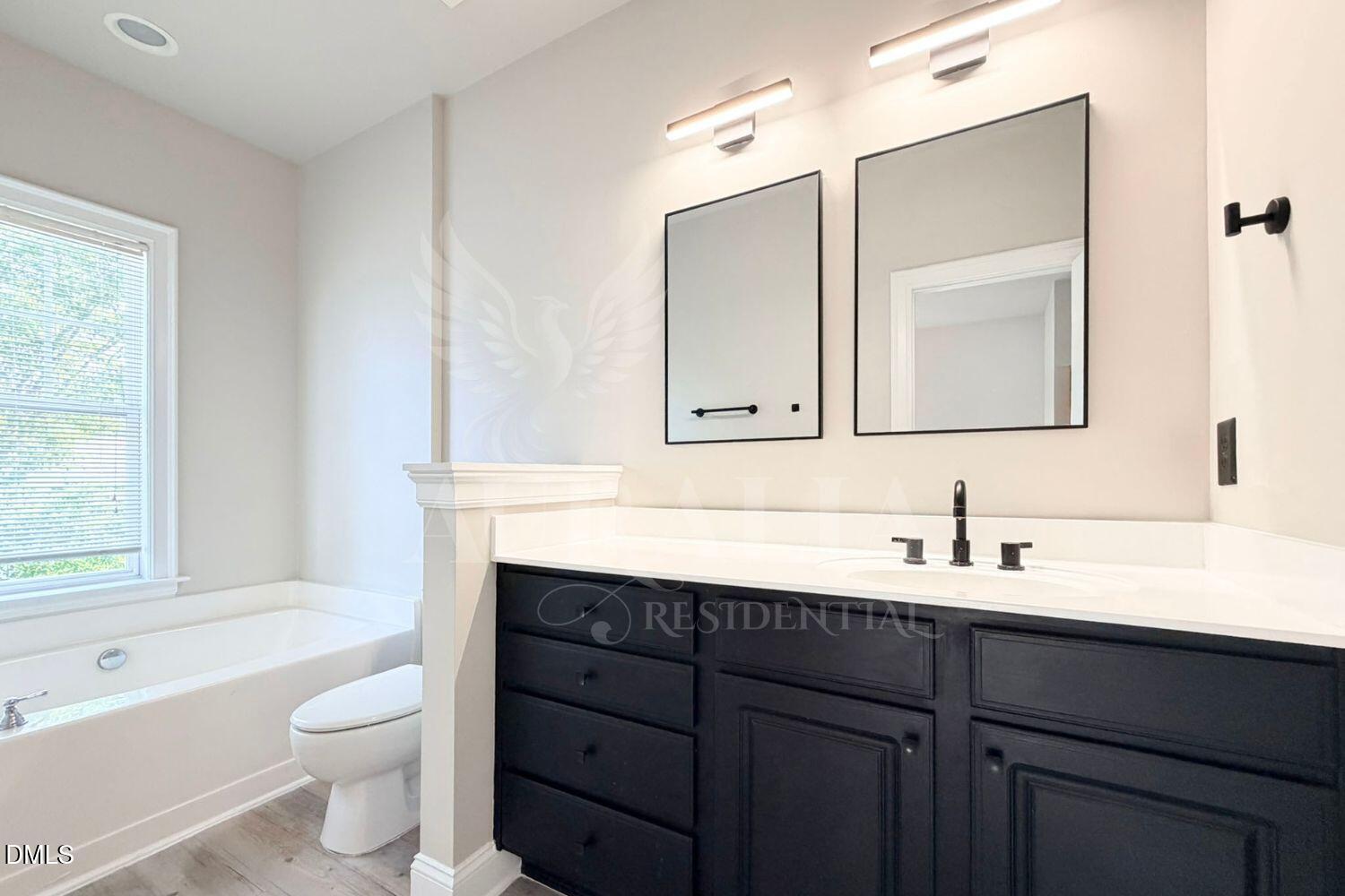 7754 ACC Boulevard Raleigh, NC 27617 - Photo 30 of 41 a bathroom with a toilet a sink a tub and a mirror