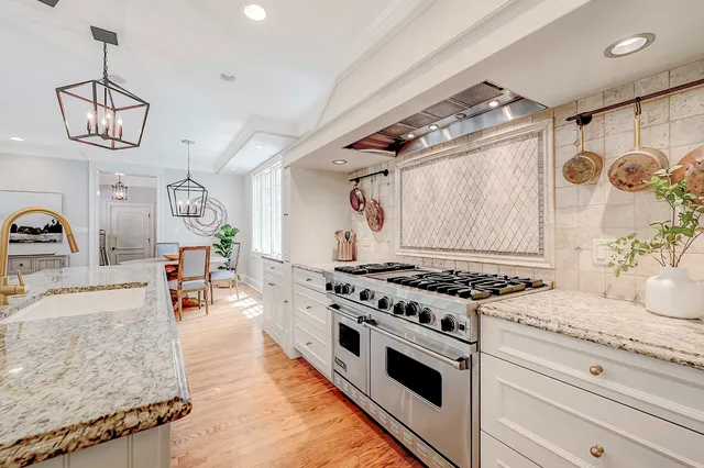 a kitchen with stainless steel appliances granite countertop a stove a sink and a refrigerator