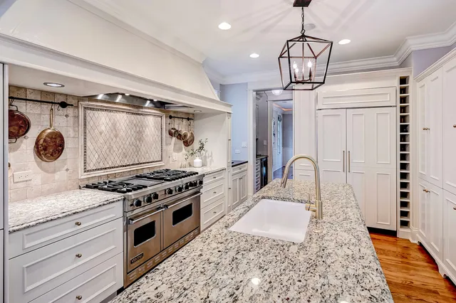 a kitchen with a table chairs refrigerator and wooden floor