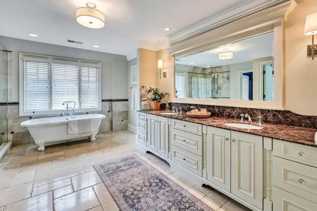 a spacious bathroom with a tub shower and windows