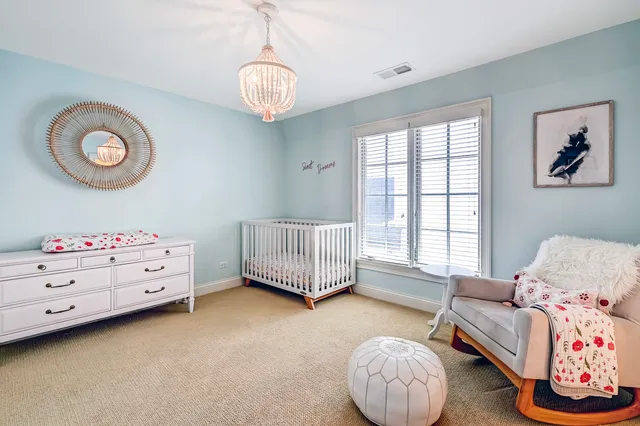 a living room with baby crib furniture and a window