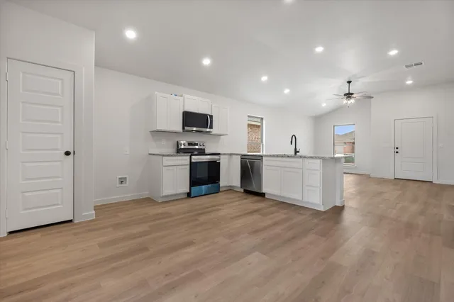 a large kitchen with cabinets and stainless steel appliances