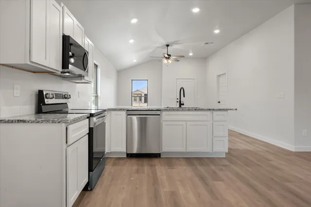 a kitchen with stainless steel appliances a sink stove and cabinets