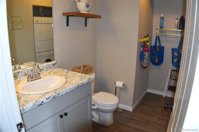 a bathroom with a granite countertop toilet sink and mirror
