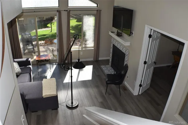 a living room with furniture a flat screen tv and a floor to ceiling window