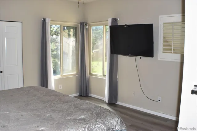 a bedroom with a bed and painting on the wall