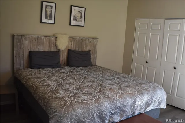 a bedroom with a bed and painting on the wall