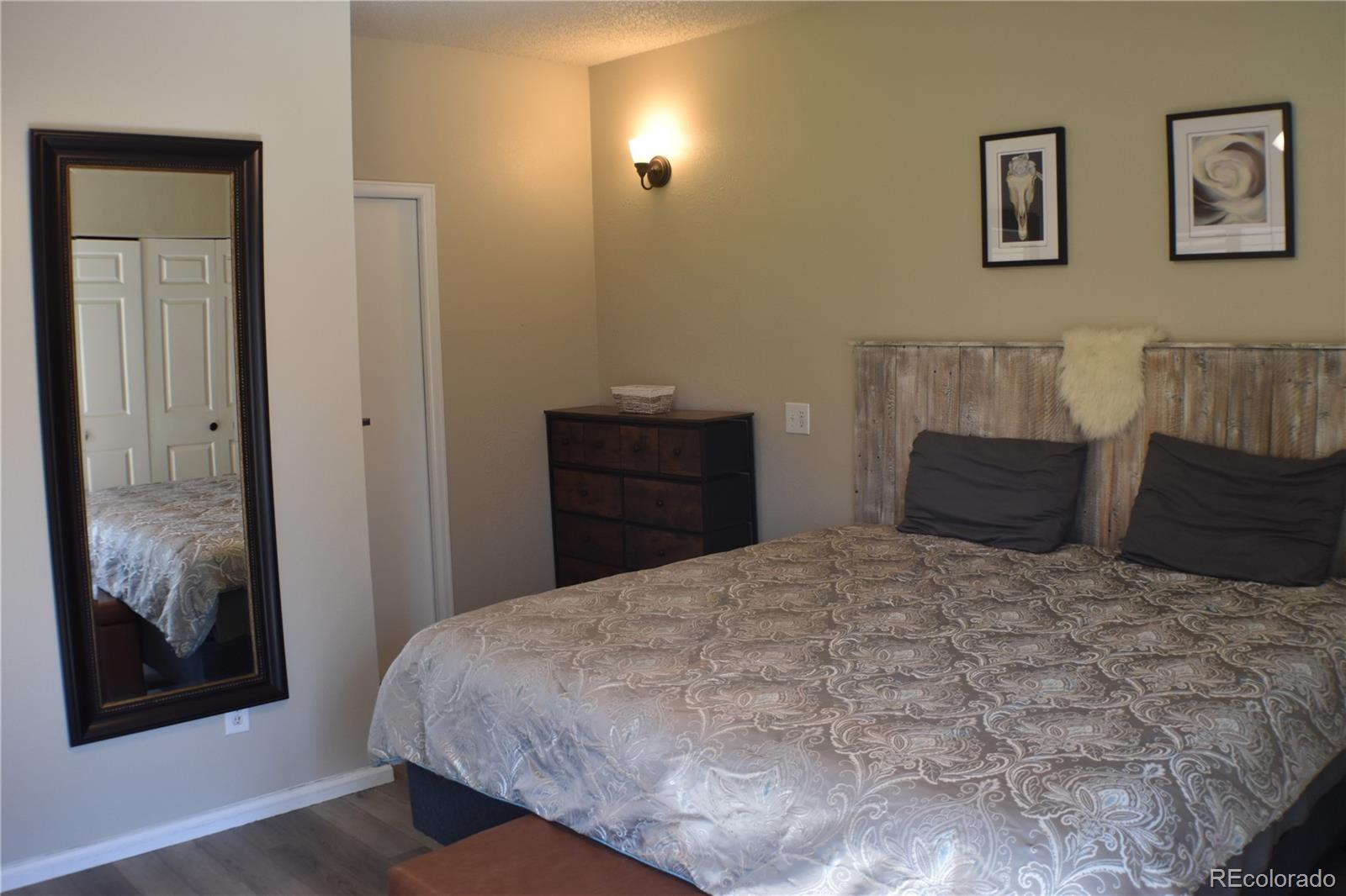 4075 Autumn Heights Drive, Unit F Colorado Springs, CO 80906 - Photo 26 of 44 a bedroom with a bed and painting on the wall