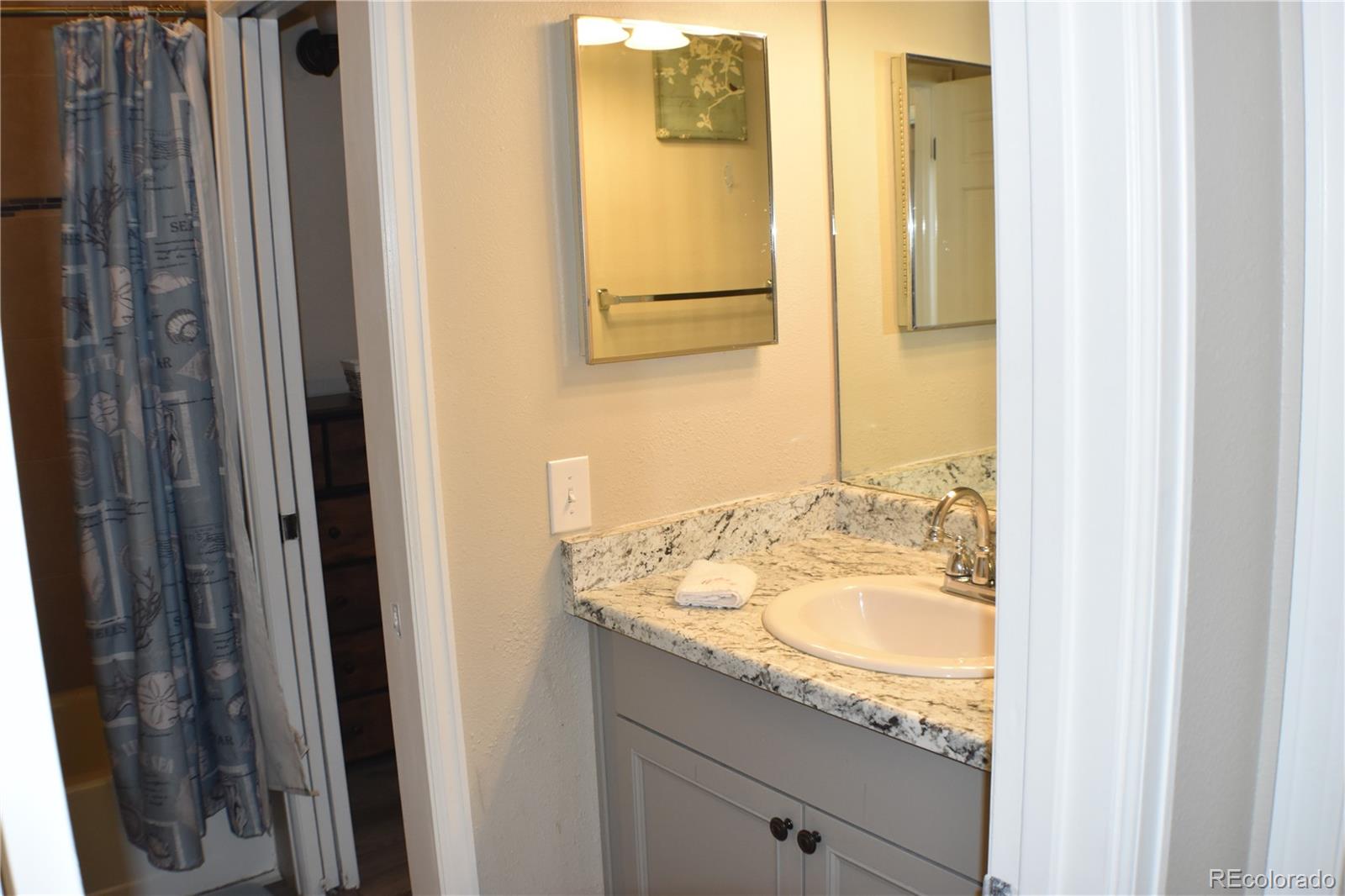 4075 Autumn Heights Drive, Unit F Colorado Springs, CO 80906 - Photo 29 of 44 a bathroom with a granite countertop sink and a mirror