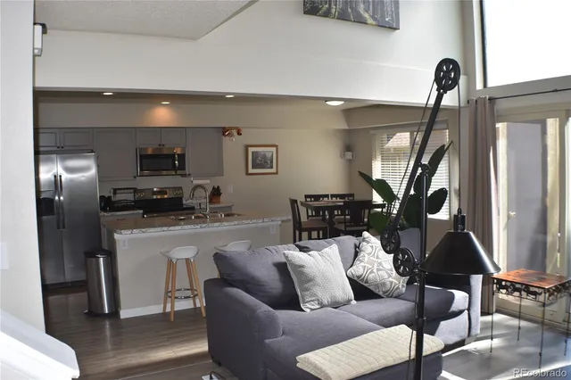 a living room with furniture a flat screen tv and a window