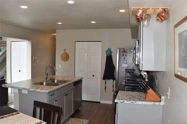 a kitchen with stainless steel appliances granite countertop a sink stove and refrigerator