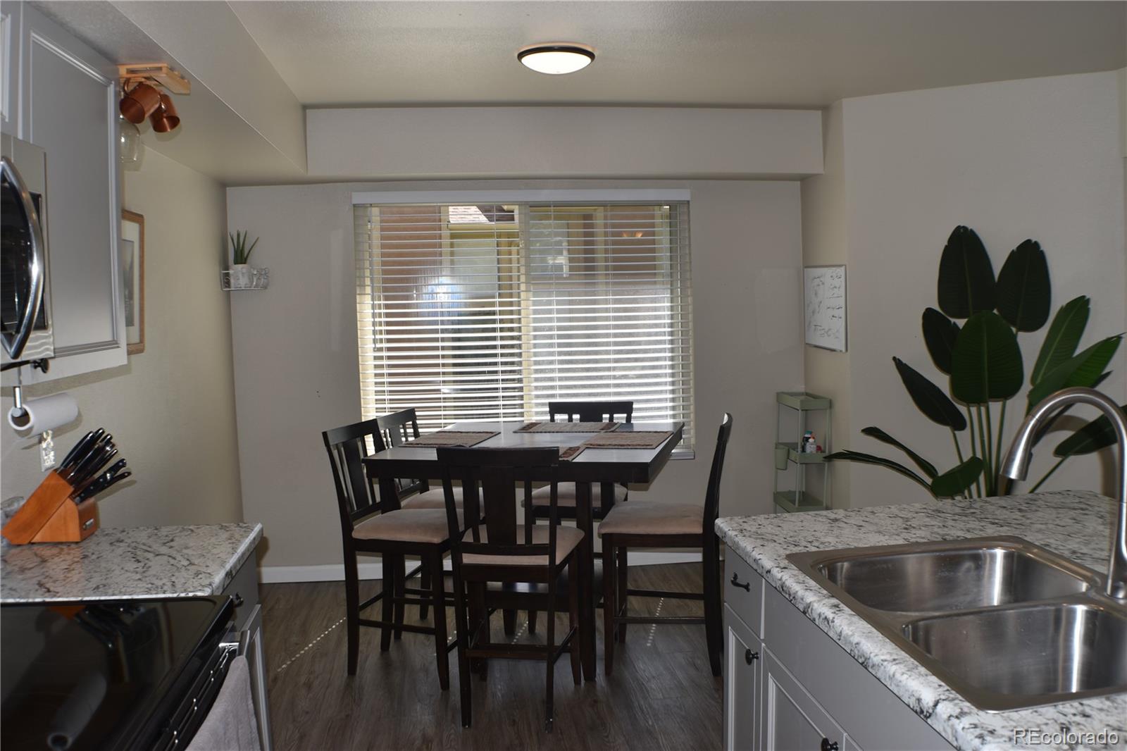 4075 Autumn Heights Drive, Unit F Colorado Springs, CO 80906 - Photo 9 of 44 a kitchen with a table chairs and microwave