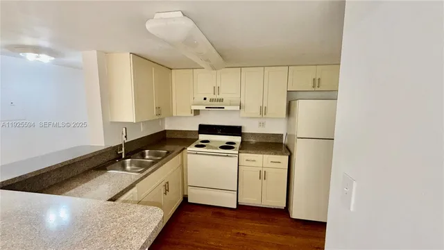 a kitchen with a stove a sink and a refrigerator