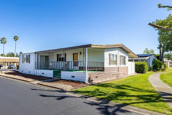 a view of a house with backyard and sitting area