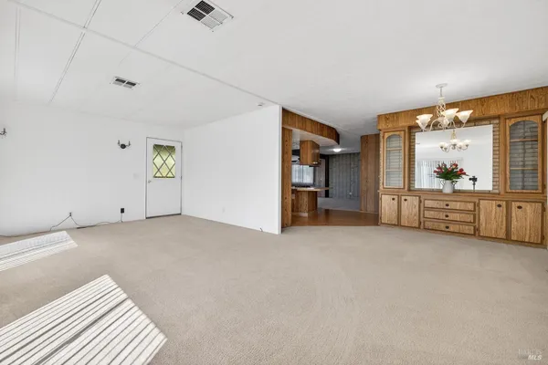a view of an empty room with closet and windows