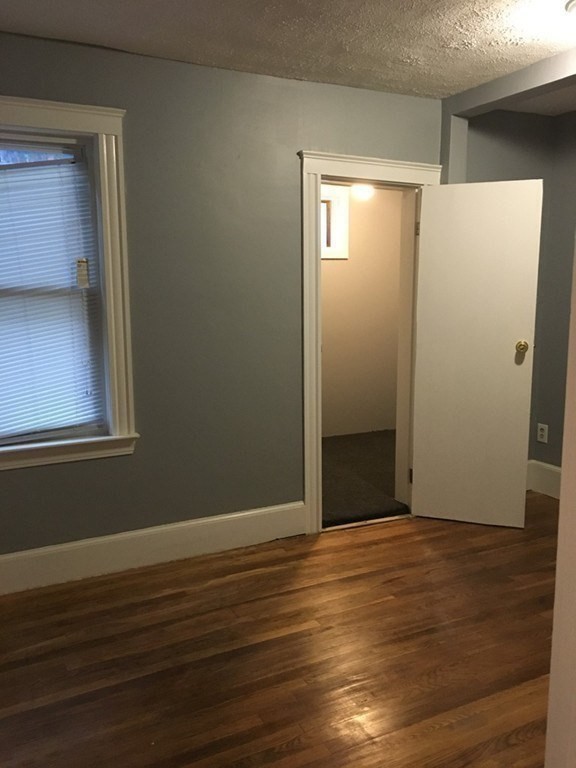 34 Grove Street Lynn, MA 01905 - Photo 11 of 37 a view of an empty room with wooden floor and a window