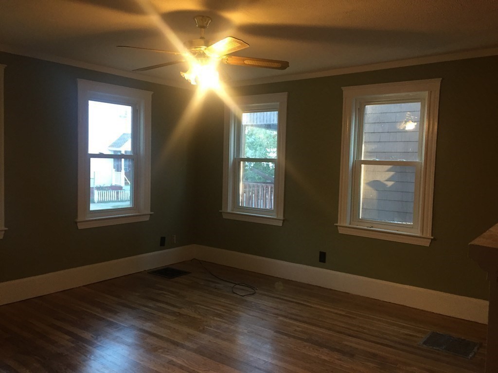 34 Grove Street Lynn, MA 01905 - Photo 12 of 37 a view of an empty room with wooden floor and a window